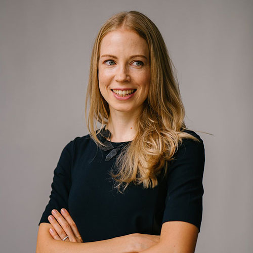 une femme souriante face à l'appareil photo