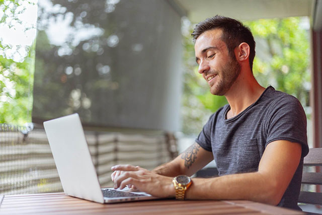 un homme qui travaille sur son ordinateur Cela représente le coworking.