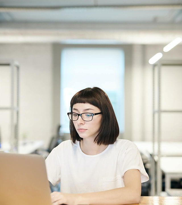 il y a une femme qui travaille sur son ordinateur portable. Cela représente le coworking.
