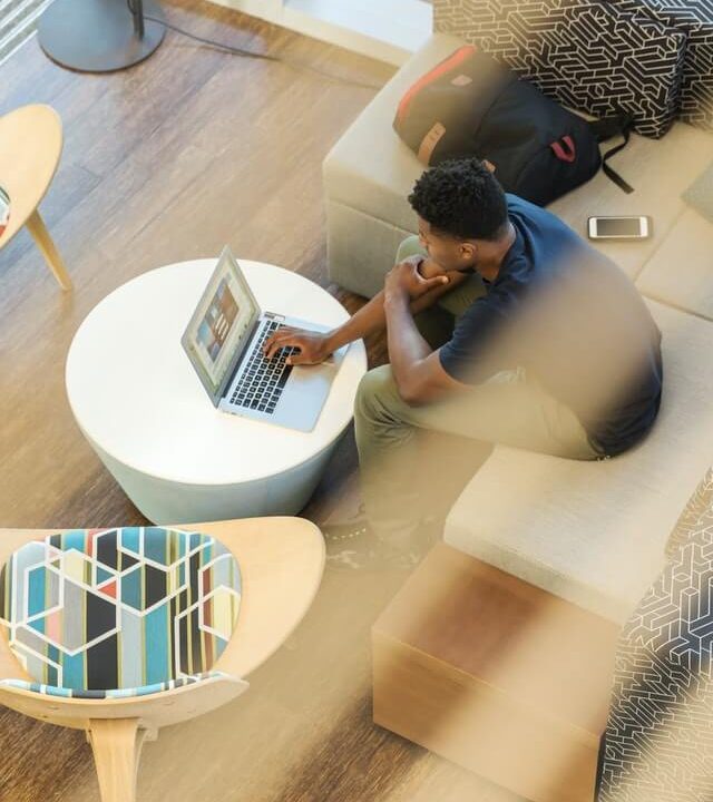 on voit un homme vus de haut travaillant sur son téléphone. Cela représente le coworking